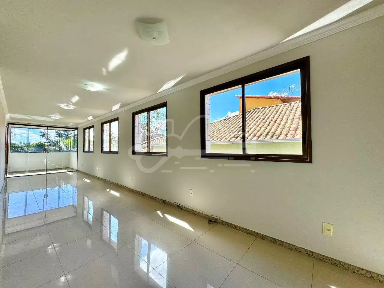 Sala ampla com piso polido e iluminação natural